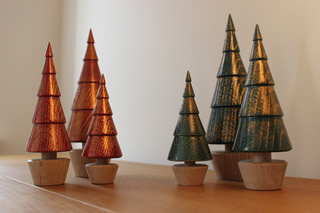 Group of red and green wooden trees with gold highlights.
