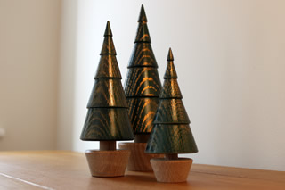 Group of green wooden trees with gold highlights.