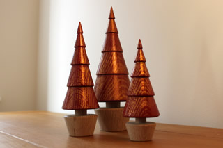 Group of red wooden trees with gold highlights.